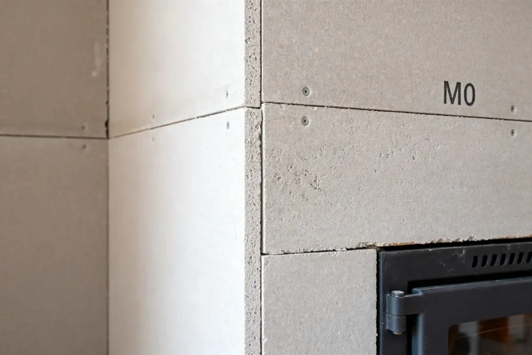 Plaques résistantes M0 pour habillage cheminée autour d'un insert métallique noir