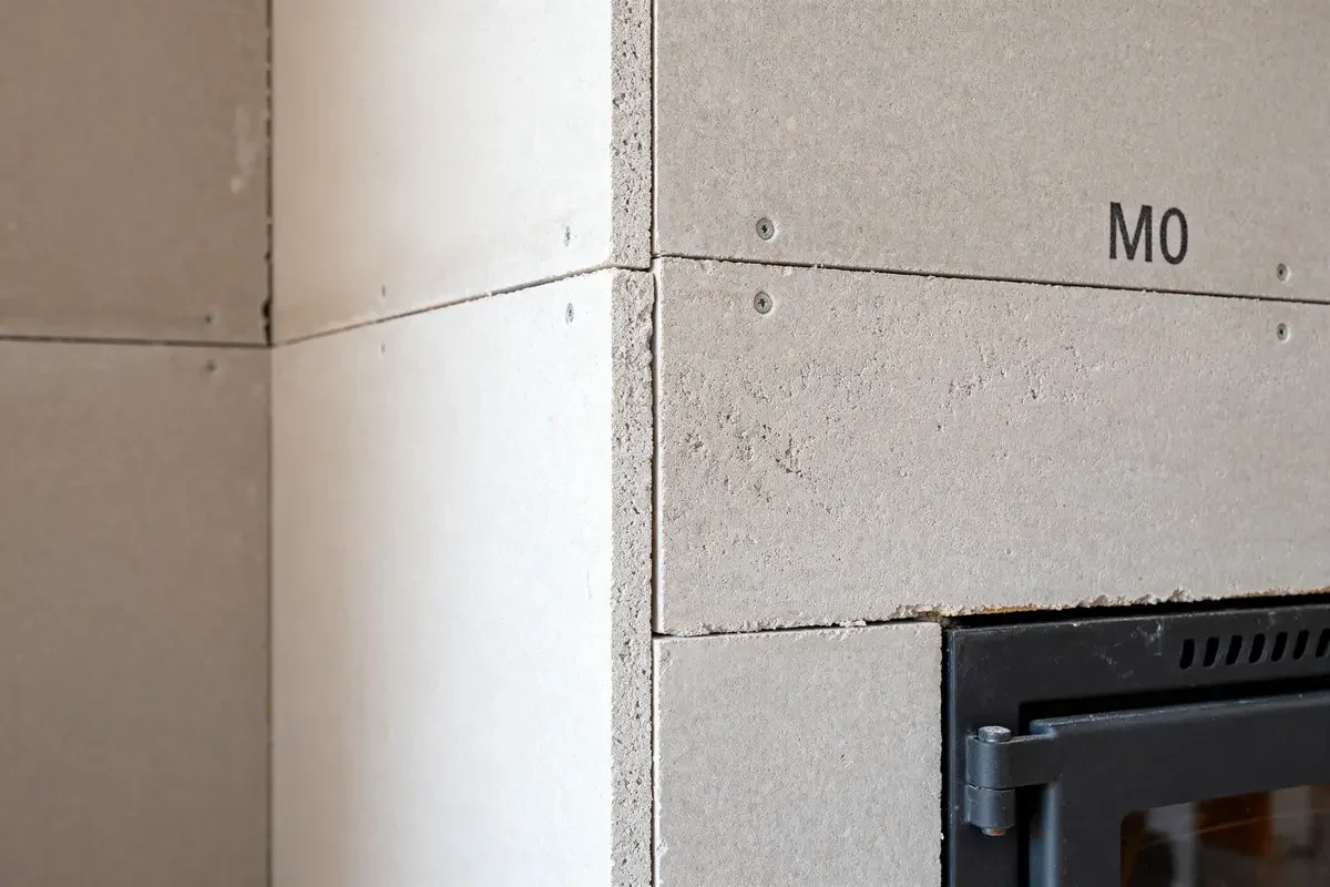 Plaques résistantes M0 pour habillage cheminée autour d'un insert métallique noir