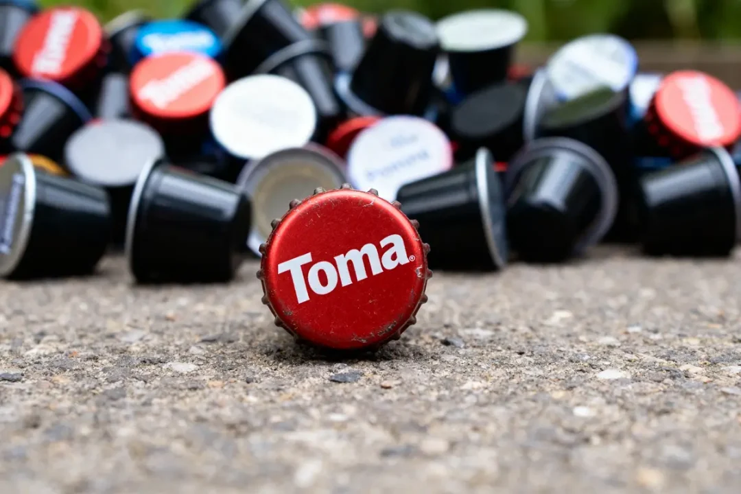 Capsules colorées empilées sur sol avec les Caps de Toma en gros plan rouge