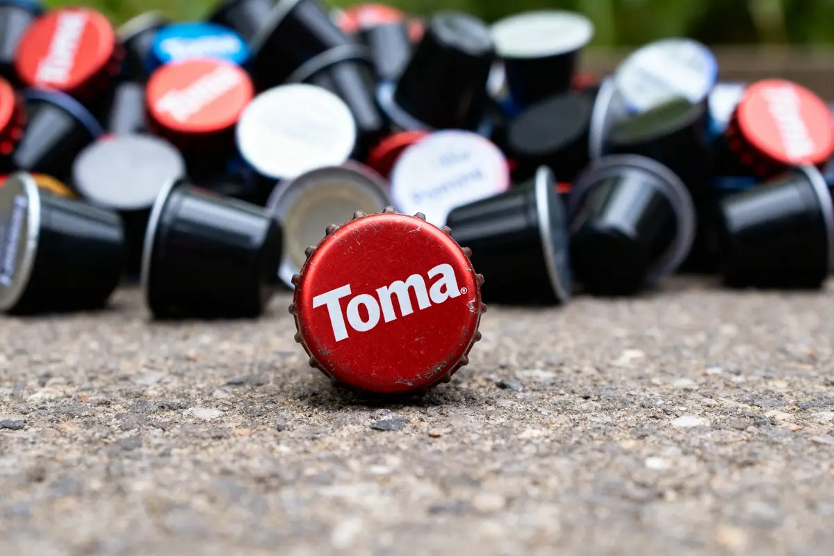 Capsules colorées empilées sur sol avec les Caps de Toma en gros plan rouge
